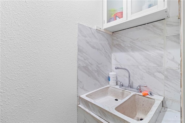 bathroom with sink and tile walls