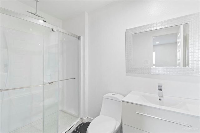 bathroom featuring vanity, toilet, and a shower with door