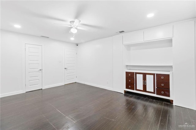 unfurnished living room with ceiling fan and dark wood-type flooring