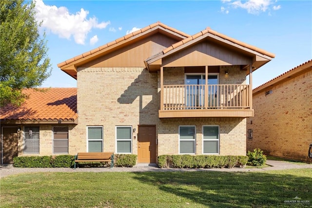 view of front of house featuring a balcony and a front lawn