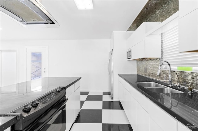 kitchen featuring decorative backsplash, appliances with stainless steel finishes, dark stone counters, sink, and white cabinetry