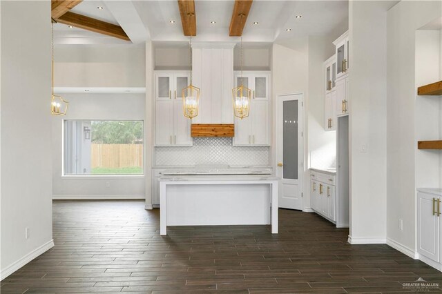 kitchen with beam ceiling, dark hardwood / wood-style flooring, white cabinetry, and pendant lighting