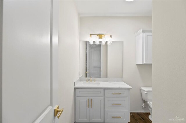 bathroom featuring toilet, vanity, and hardwood / wood-style flooring