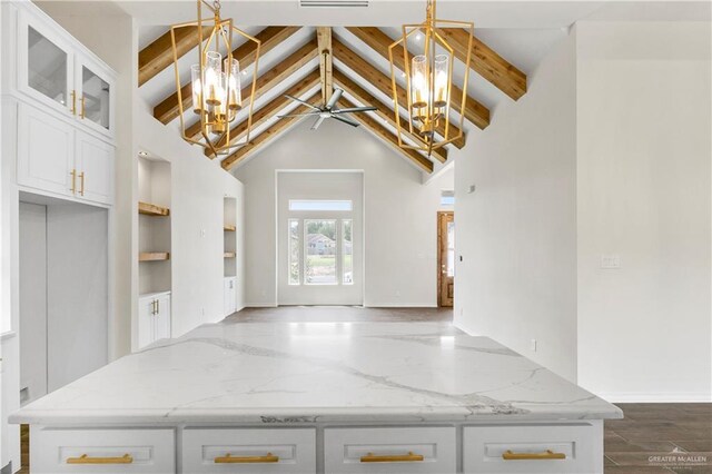 kitchen with white cabinets, dark hardwood / wood-style floors, beam ceiling, and light stone countertops