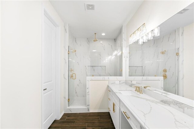 bathroom with hardwood / wood-style floors, vanity, and a shower with shower door