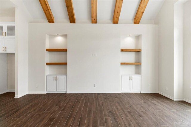 unfurnished living room featuring built in shelves, beam ceiling, and dark wood-type flooring