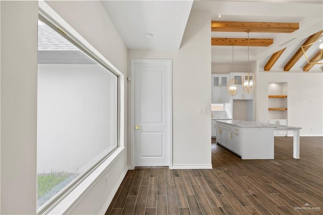 interior space with a breakfast bar, decorative light fixtures, a chandelier, dark hardwood / wood-style floors, and white cabinetry