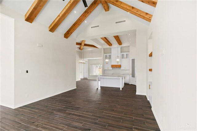 unfurnished living room with beam ceiling, dark hardwood / wood-style flooring, and high vaulted ceiling