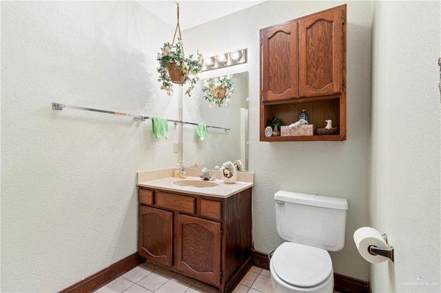 bathroom with toilet, tile patterned flooring, baseboards, and vanity