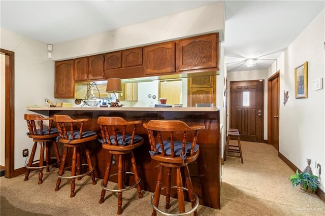 bar featuring built in refrigerator, carpet flooring, and baseboards