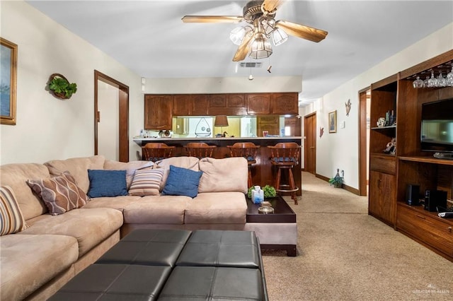 living room with a ceiling fan, light carpet, visible vents, and baseboards