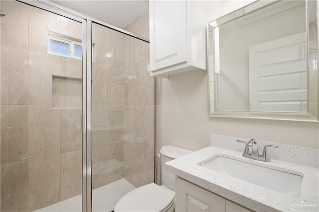 bathroom with vanity, toilet, and a shower with door