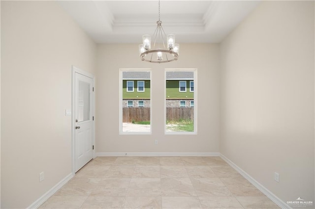 unfurnished room with a raised ceiling and a chandelier