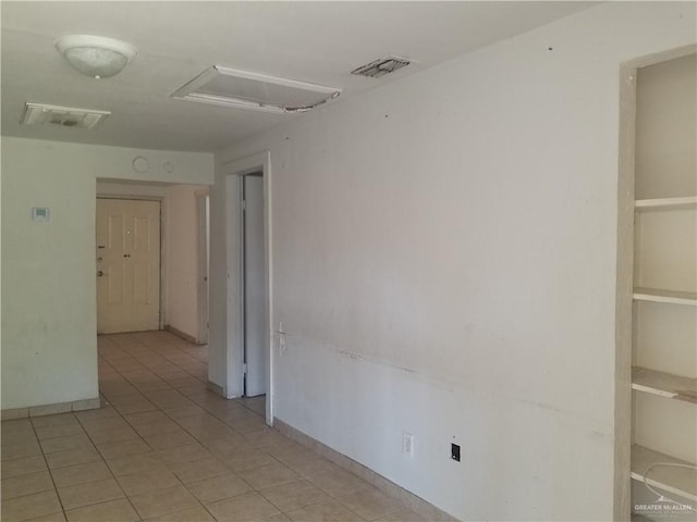 515 Holland Ave, Mission, TX 78572 - spare room featuring attic access, light tile patterned flooring, and baseboards