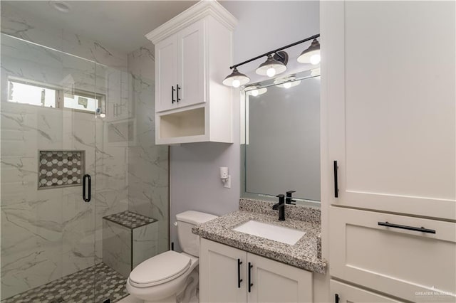 bathroom with vanity, a shower with shower door, and toilet