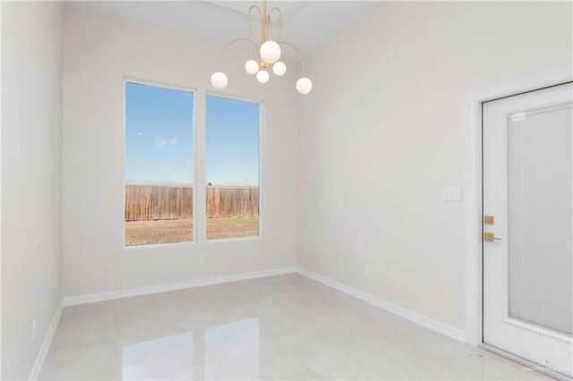 unfurnished room featuring baseboards and a notable chandelier