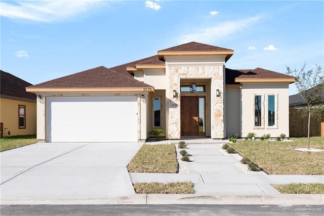 prairie-style home featuring a garage, stone siding, concrete driveway, and stucco siding