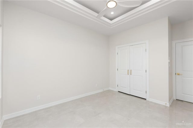 unfurnished bedroom with a closet, recessed lighting, a raised ceiling, and baseboards