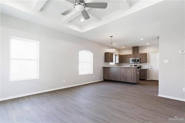 kitchen with kitchen peninsula, dark hardwood / wood-style floors, hanging light fixtures, and ceiling fan