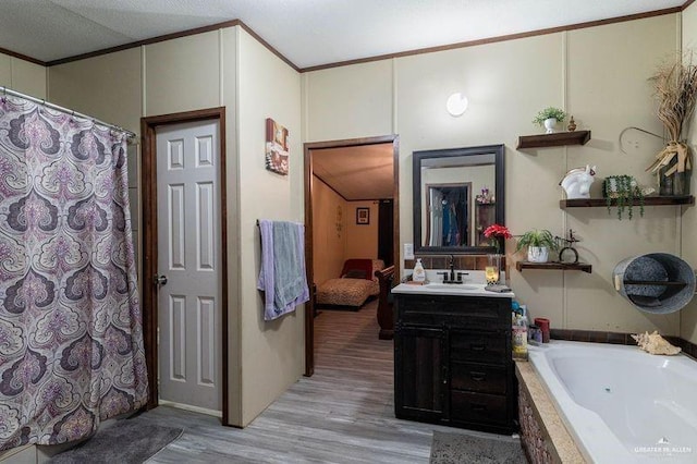 full bath featuring ornamental molding, tiled bath, vanity, and wood finished floors