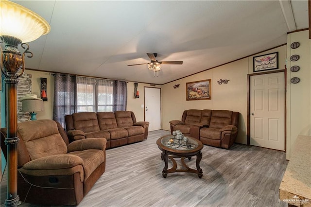 living room featuring a ceiling fan, vaulted ceiling, and wood finished floors