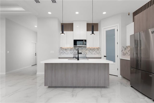 kitchen featuring stainless steel appliances, sink, pendant lighting, a center island with sink, and white cabinetry