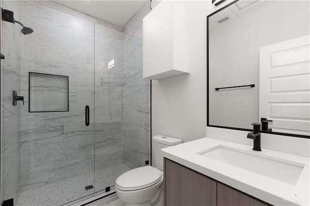 bathroom with vanity, toilet, and a shower with shower door