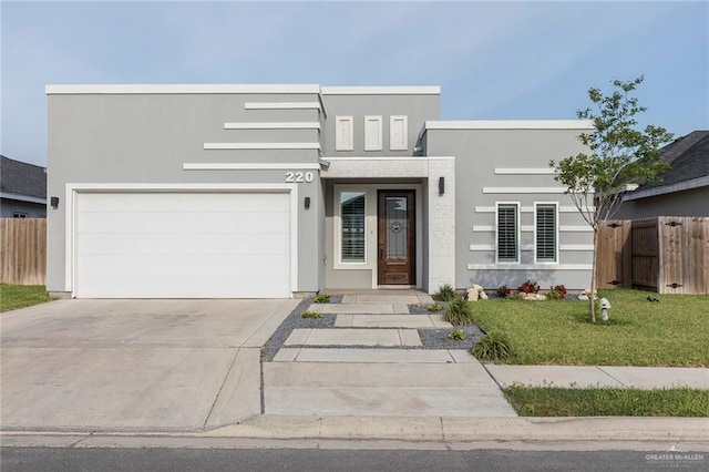220 Stella Dr, San Juan, TX 78589 - modern home featuring stucco siding, a front yard, concrete driveway, and fence