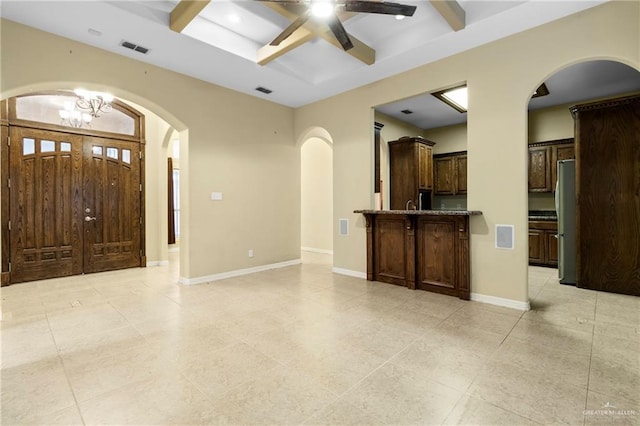 interior space with beamed ceiling, coffered ceiling, and ceiling fan with notable chandelier