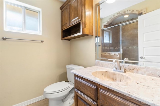 bathroom with vanity, a shower with shower door, and toilet