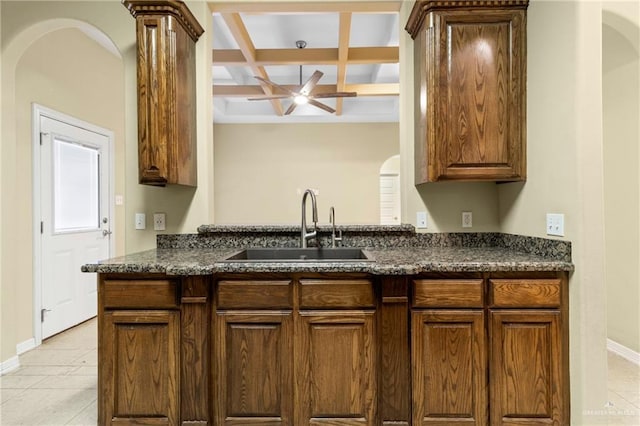 kitchen with coffered ceiling, sink, light tile patterned floors, ceiling fan, and beam ceiling