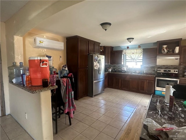 kitchen featuring dark brown cabinetry, backsplash, a wall mounted AC, light tile patterned floors, and appliances with stainless steel finishes