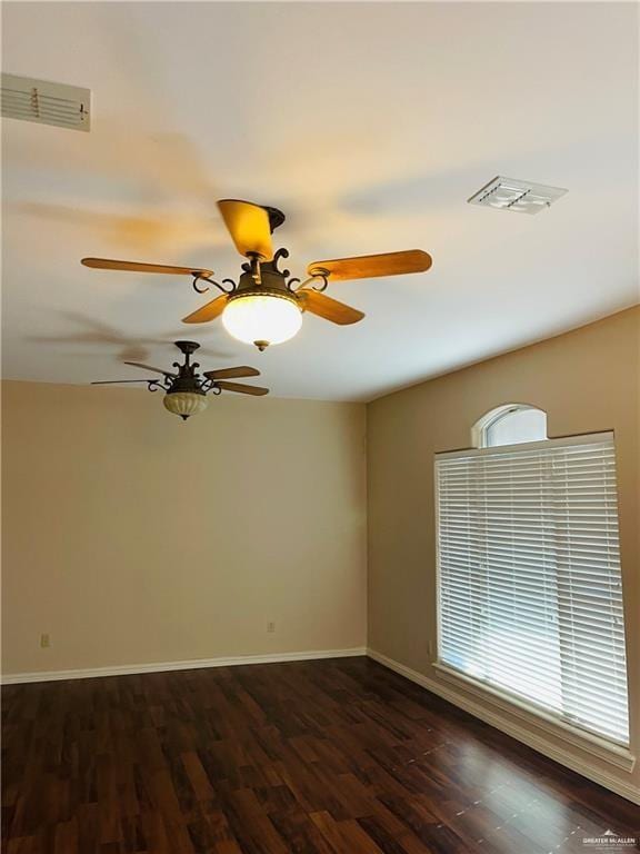 empty room with dark wood finished floors, baseboards, and a ceiling fan
