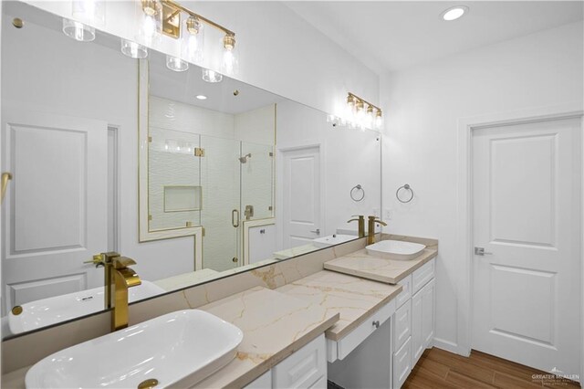 556 Demi St, Edinburg, TX 78542 - bathroom featuring a shower stall, double vanity, a sink, and wood finished floors
