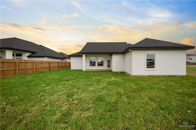 556 Demi St, Edinburg, TX 78542 - rear view of house with a yard, stucco siding, a shingled roof, and fence