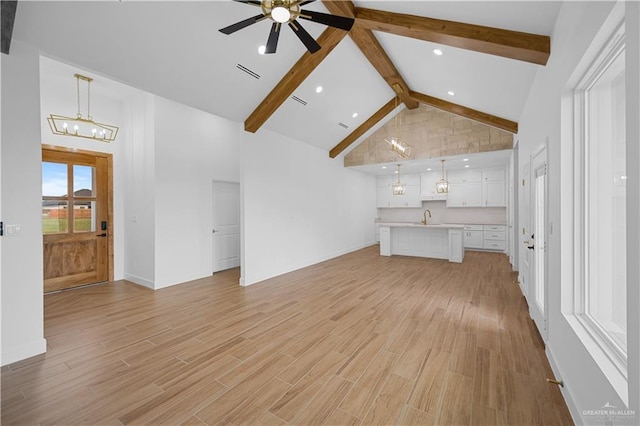 556 Demi St, Edinburg, TX 78542 - unfurnished living room with light wood-style flooring, ceiling fan with notable chandelier, a sink, beam ceiling, and visible vents