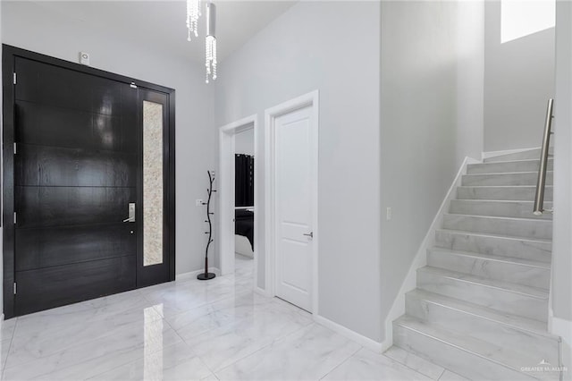 entryway featuring stairway, baseboards, and marble finish floor