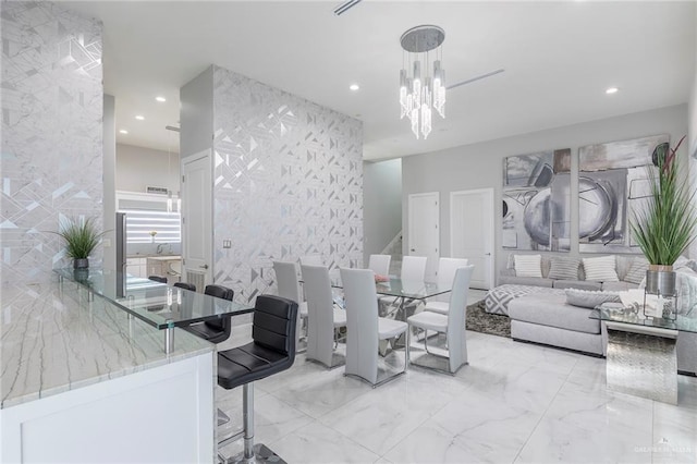 dining space with recessed lighting, marble finish floor, and a chandelier