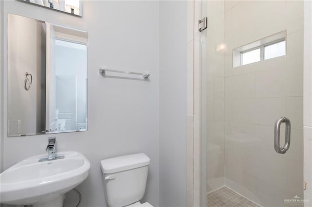 full bath featuring a sink, a stall shower, and toilet