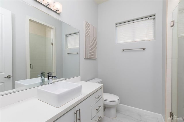 full bathroom with vanity, toilet, marble finish floor, baseboards, and a stall shower