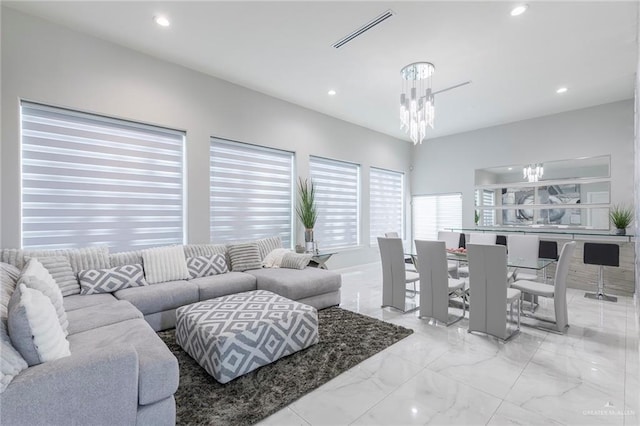 living room with marble finish floor, a notable chandelier, recessed lighting, and visible vents