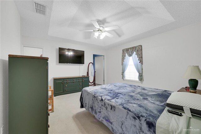 1700 Aries St, Mission, TX 78572 - bedroom featuring a textured ceiling, light colored carpet, a raised ceiling, and a ceiling fan
