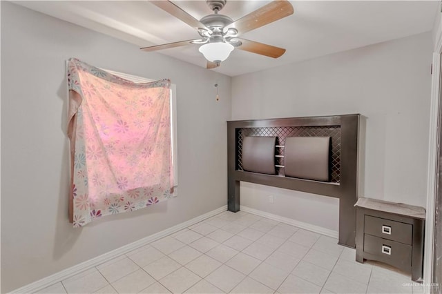 spare room with baseboards, ceiling fan, and light tile patterned flooring