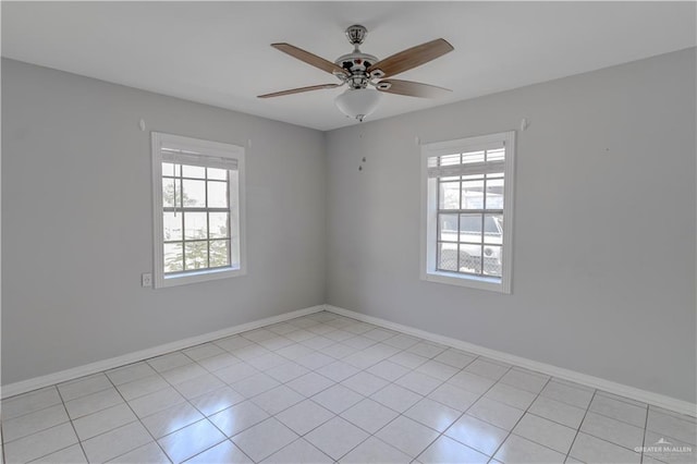 unfurnished room with light tile patterned floors, ceiling fan, plenty of natural light, and baseboards