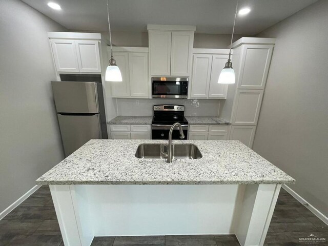 kitchen with white cabinets, stainless steel appliances, a kitchen island with sink, and sink