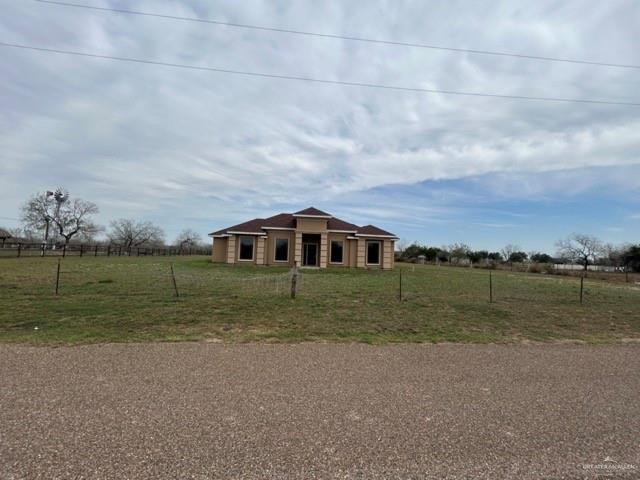 ranch-style home featuring a front lawn and a rural view