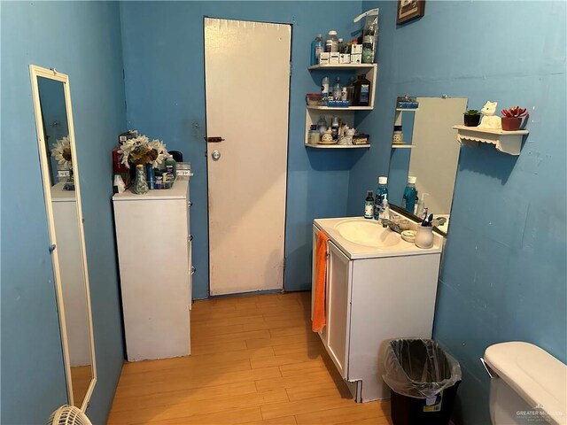 bathroom with hardwood / wood-style floors, vanity, and toilet