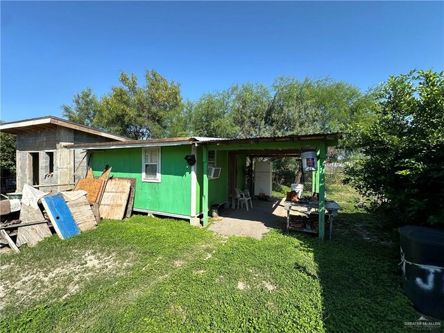 back of property featuring cooling unit and a lawn