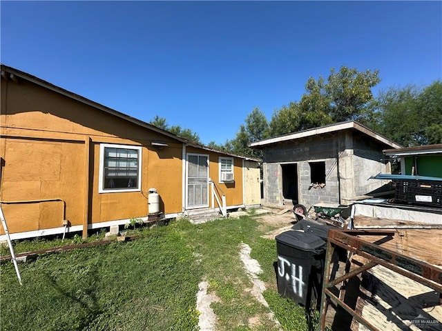 back of house with a yard and an outdoor structure