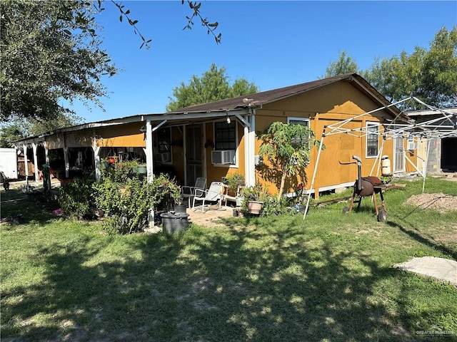 rear view of property featuring a lawn and cooling unit